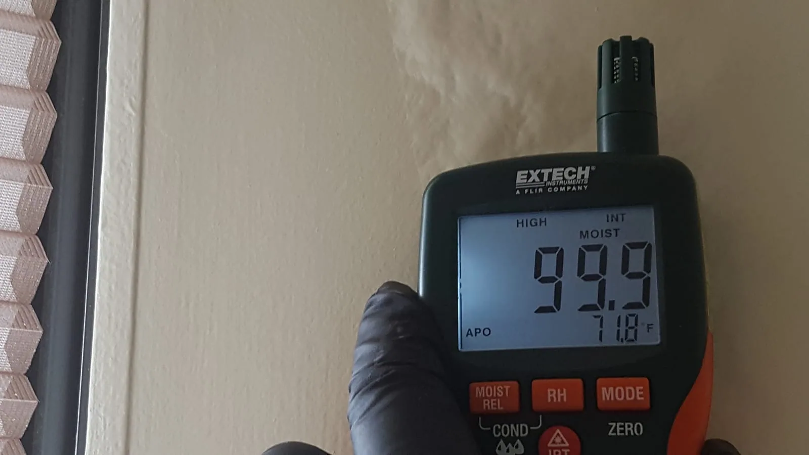 Moisture meter verifying drying progress in hardwood floors