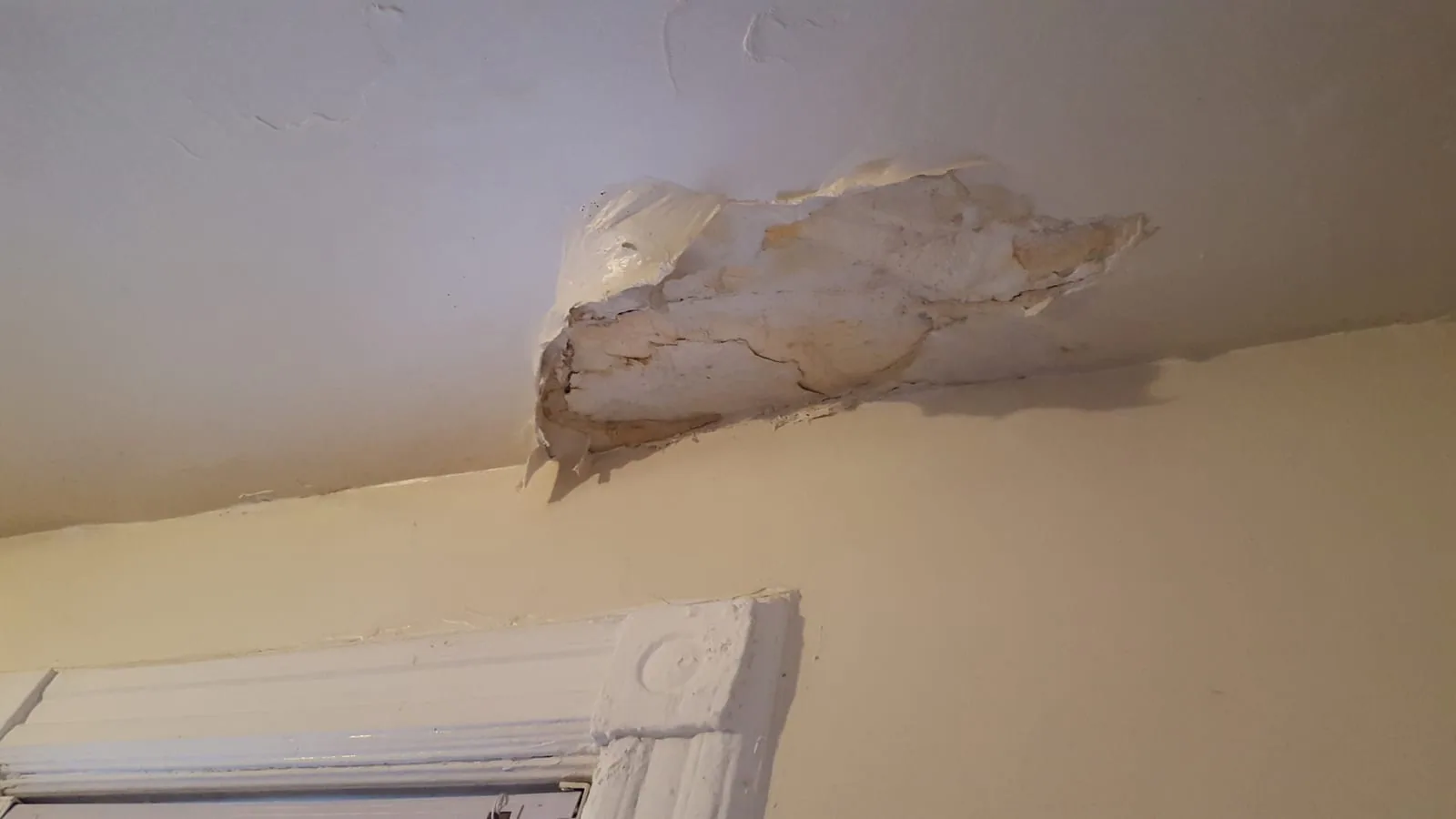Brown water stain spreading across drywall ceiling from an active leak above
